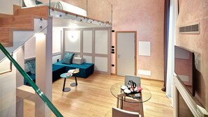 A modern interior with a staircase, a seating area with cushions, a glass table with items, and a door. - Ca' Dei Proverbi Suites - Wenice Deep Culture (Venice)