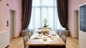 A dining area with a wooden table set for breakfast, featuring plates, cups, and a vase of flowers. - Ca' Dei Proverbi Suites - Wenice Deep Culture (Venice)