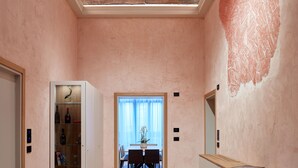 A spacious hallway with wooden flooring, a glass cabinet, and a dining area in the background. - Ca' Dei Proverbi Suites - Wenice Deep Culture (Venice)