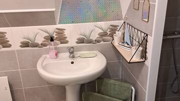 A bathroom with a sink, a window, and a towel rack.