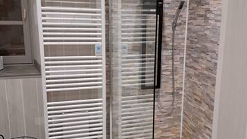 Een douche, een haardroger, handdoeken, toiletpapier