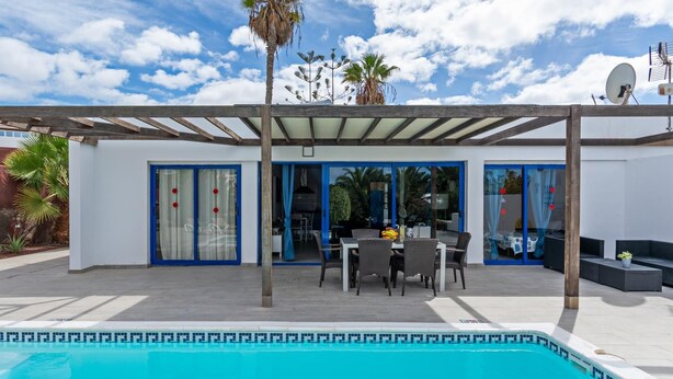 A covered outdoor pool area with a patio, a dining table, and chairs. - Villa Valentina Private Pool Playa Blanca By PVL (playa blanca)