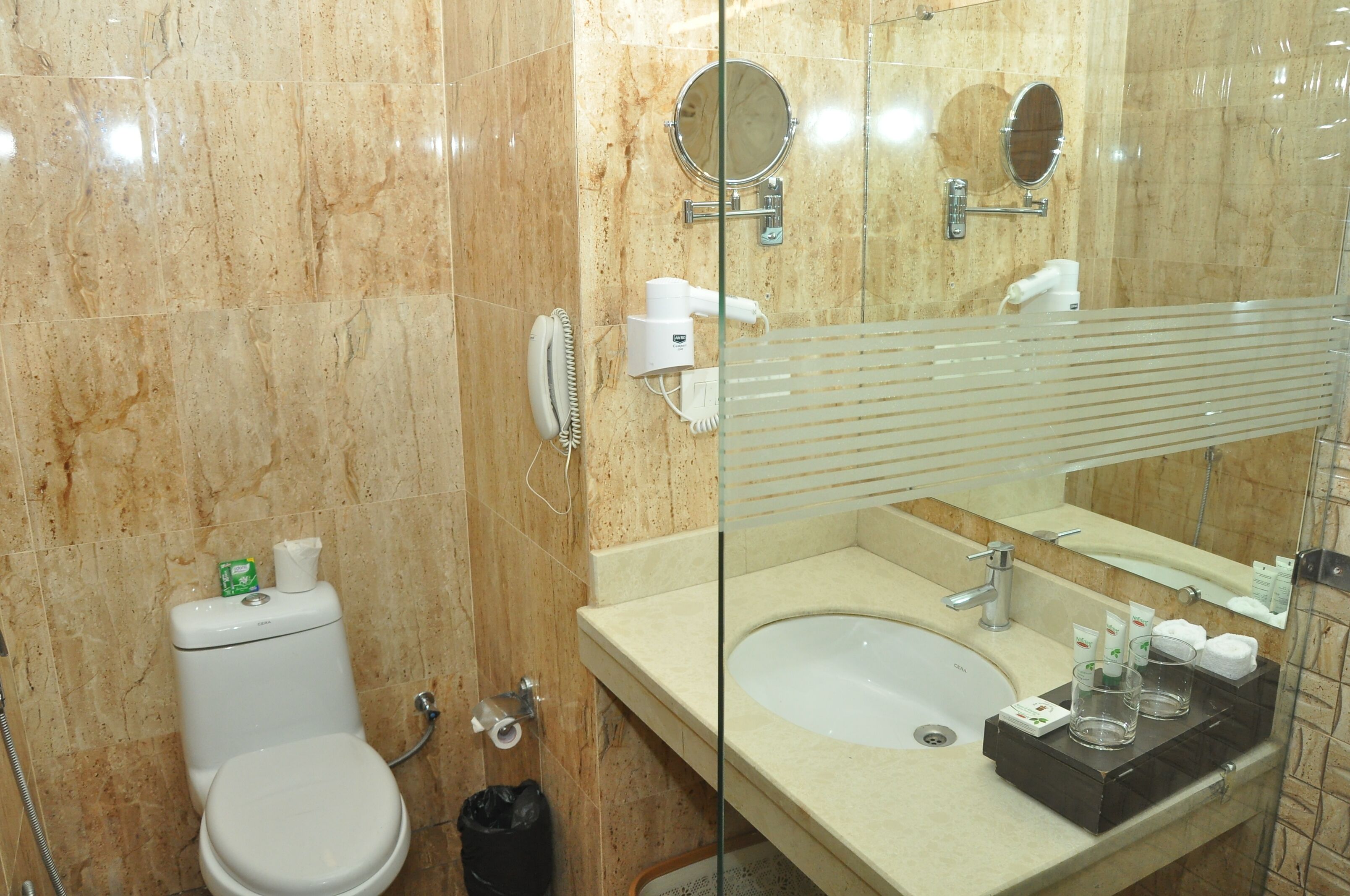 A bathroom with a toilet, sink, and mirror.