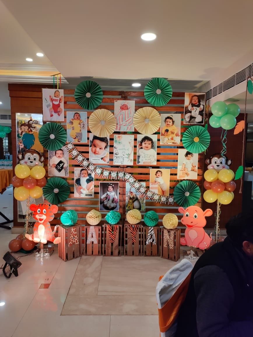 Un espacio decorado para un evento, con un fondo de madera, globos y diversas decoraciones de papel.