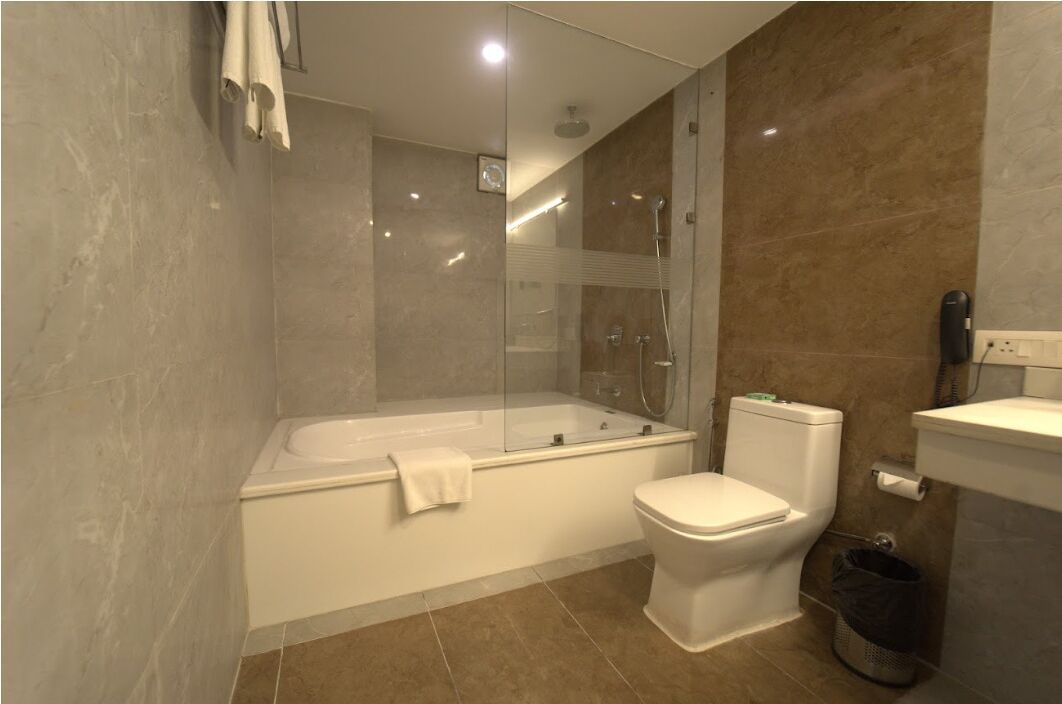 Un baño moderno con ducha de vidrio, inodoro independiente y bañera.