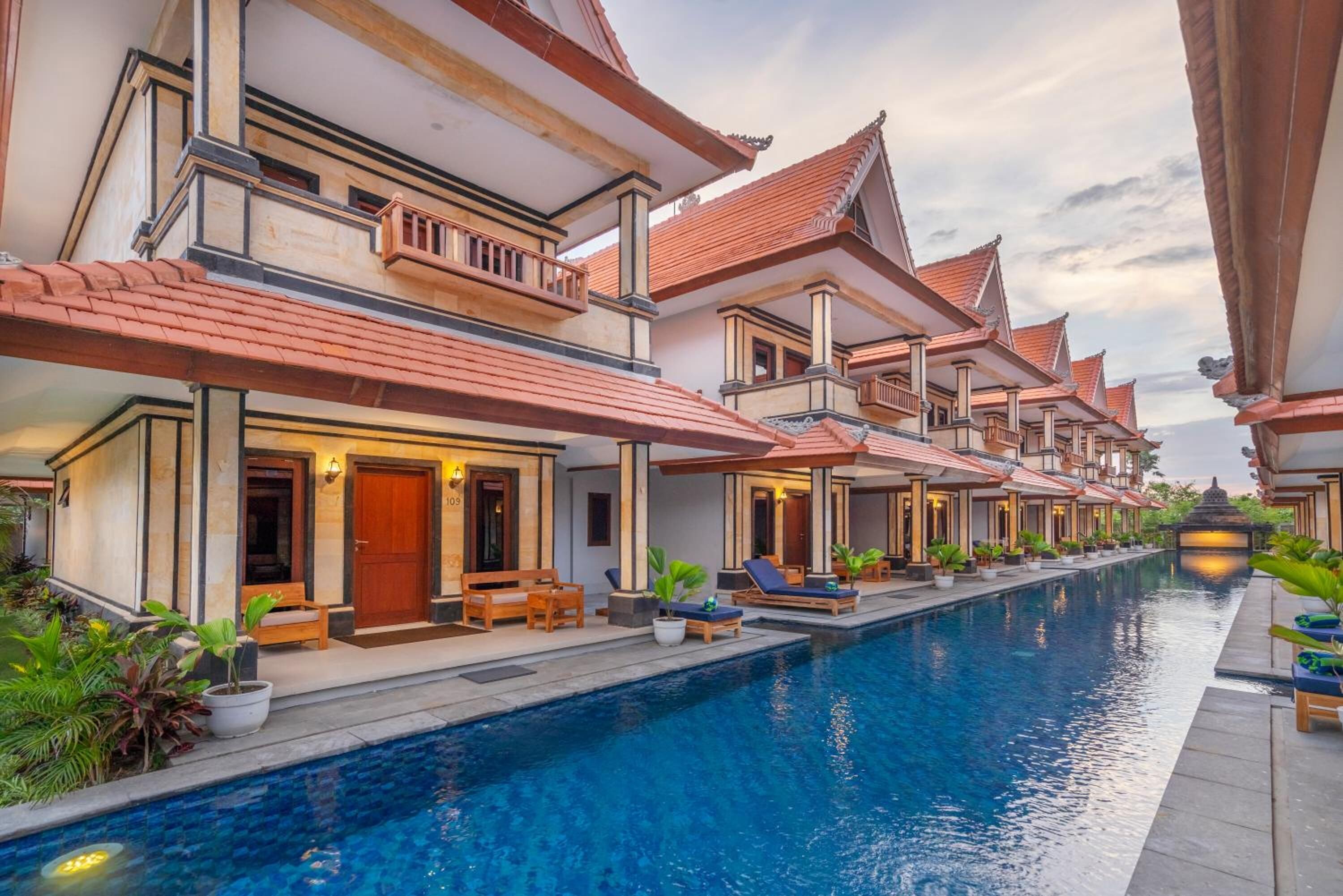 A row of traditional-style villas with a swimming pool in the center.