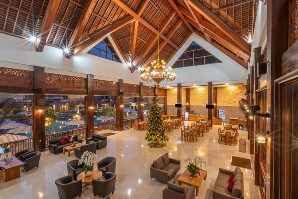 A spacious lobby with a high wooden ceiling, a large chandelier, and a Christmas tree. - The Salila Beach Resort (Keroboken Kelod)
