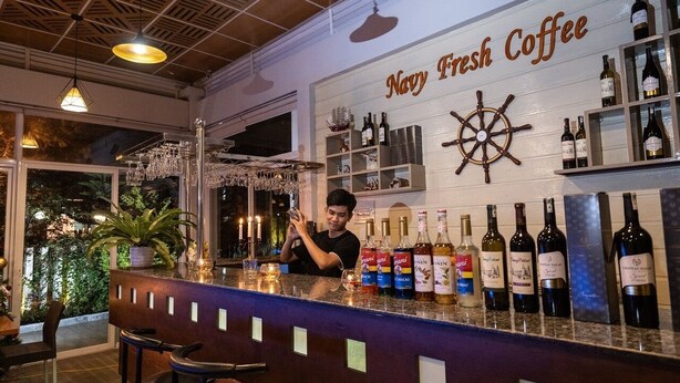 A bar area with a sign reading "Navy Fresh Coffee" and various bottles of wine and spirits. - Navy Hotel Da Lat (Lam Vien - Da Lat)
