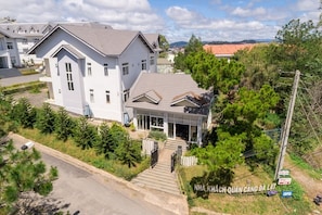 A two-story residential building with a covered porch and a driveway leading to the entrance. - Navy Hotel Da Lat (Lam Vien - Da Lat)