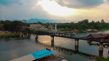 A river with a bridge, a statue, and buildings in the background.