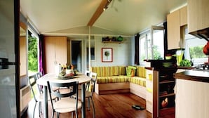 Eine gemütliche, moderne Küche mit Holzschränken, einem Esstisch mit Stühlen und einer eingebauten Sitzecke.