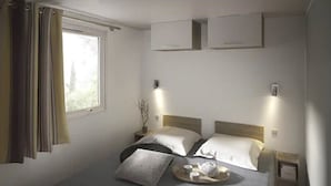 Ein Schlafzimmer mit zwei Betten, einem Fenster mit Vorhängen, Nachttischen und einem Tablett mit Teekanne und Tassen.