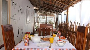 Una mesa para el desayuno lista, con mantel a cuadros, platos, tazas y diferentes opciones para el desayuno.