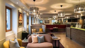 A modern interior with seating areas, a bar, and pendant lighting.