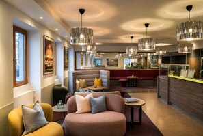 Een modern interieur met zithoeken, een bar en hanglampen.