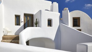 Un edificio blanco con una escalera curva y una puerta.
