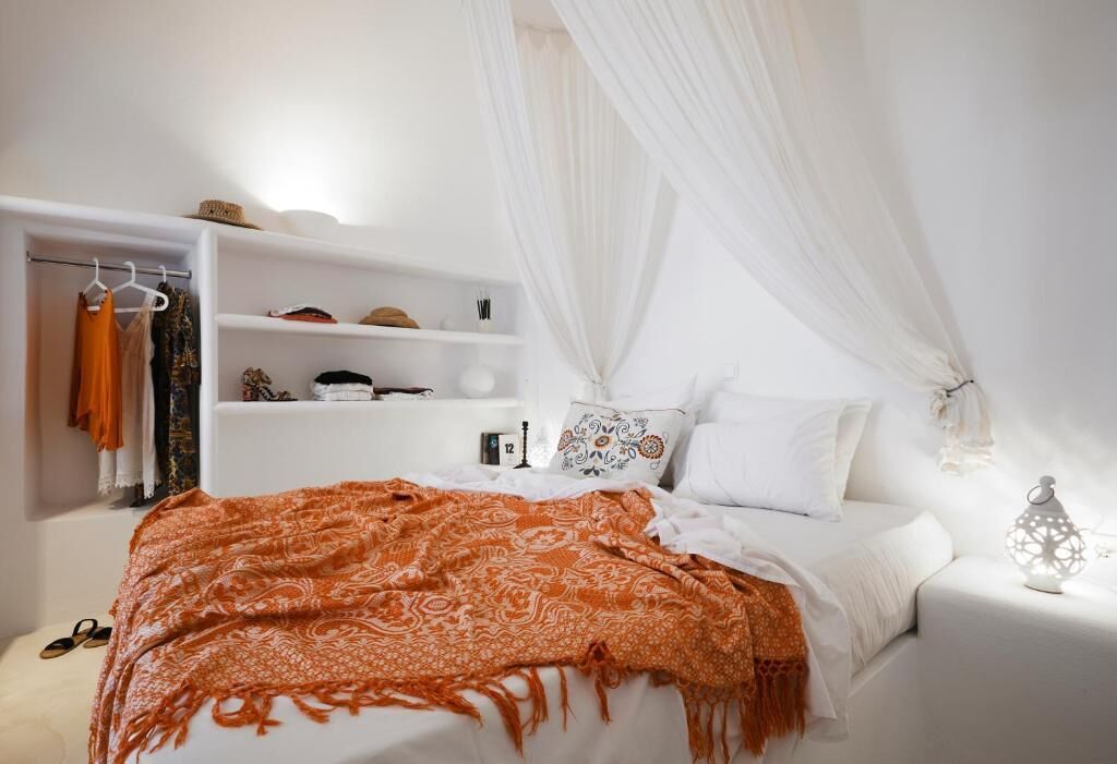 A bedroom with a bed, a wardrobe, a nightstand, and a bedside table.