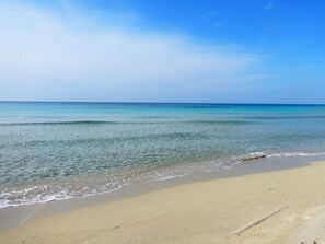 A beach with clear water and a sandy shore.