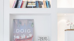 A neatly organized bookshelf with books and a framed picture. - Modern Holland Park apartment (London)