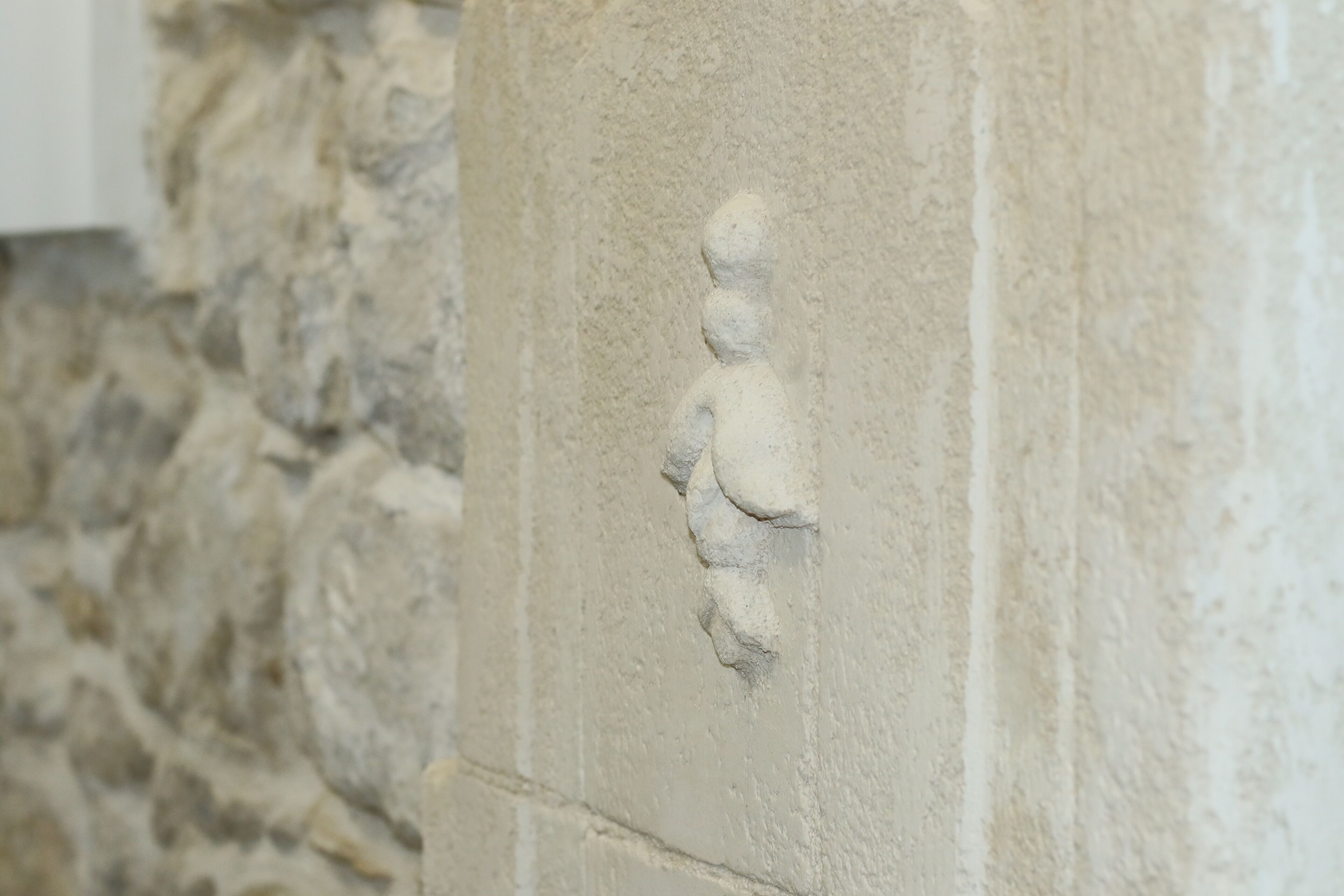 Un muro de piedra con una figura tallada.