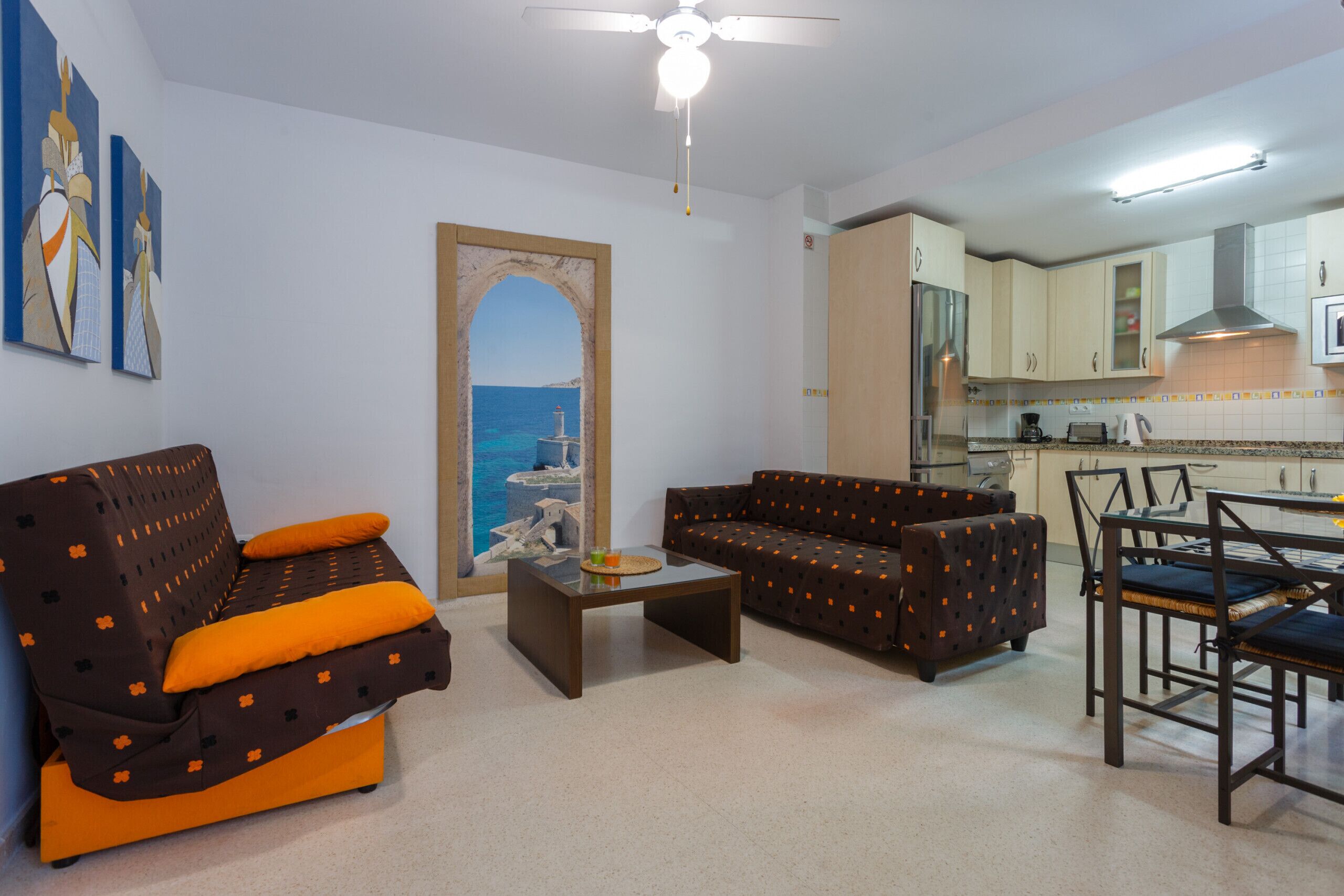 A living room with a sofa, a coffee table, and a dining area with chairs and a table.