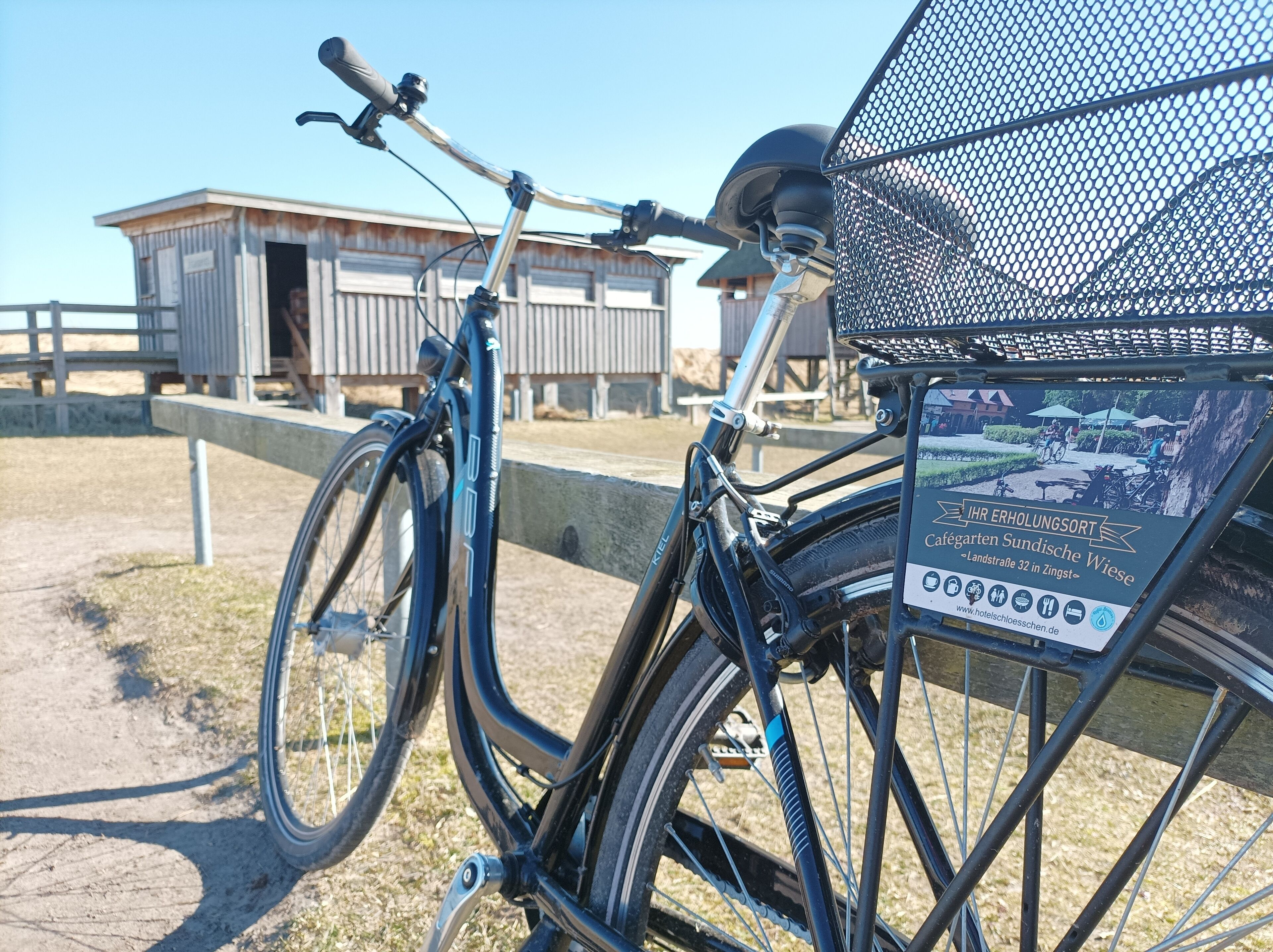 A bicycle with a basket and a sign indicating a café.