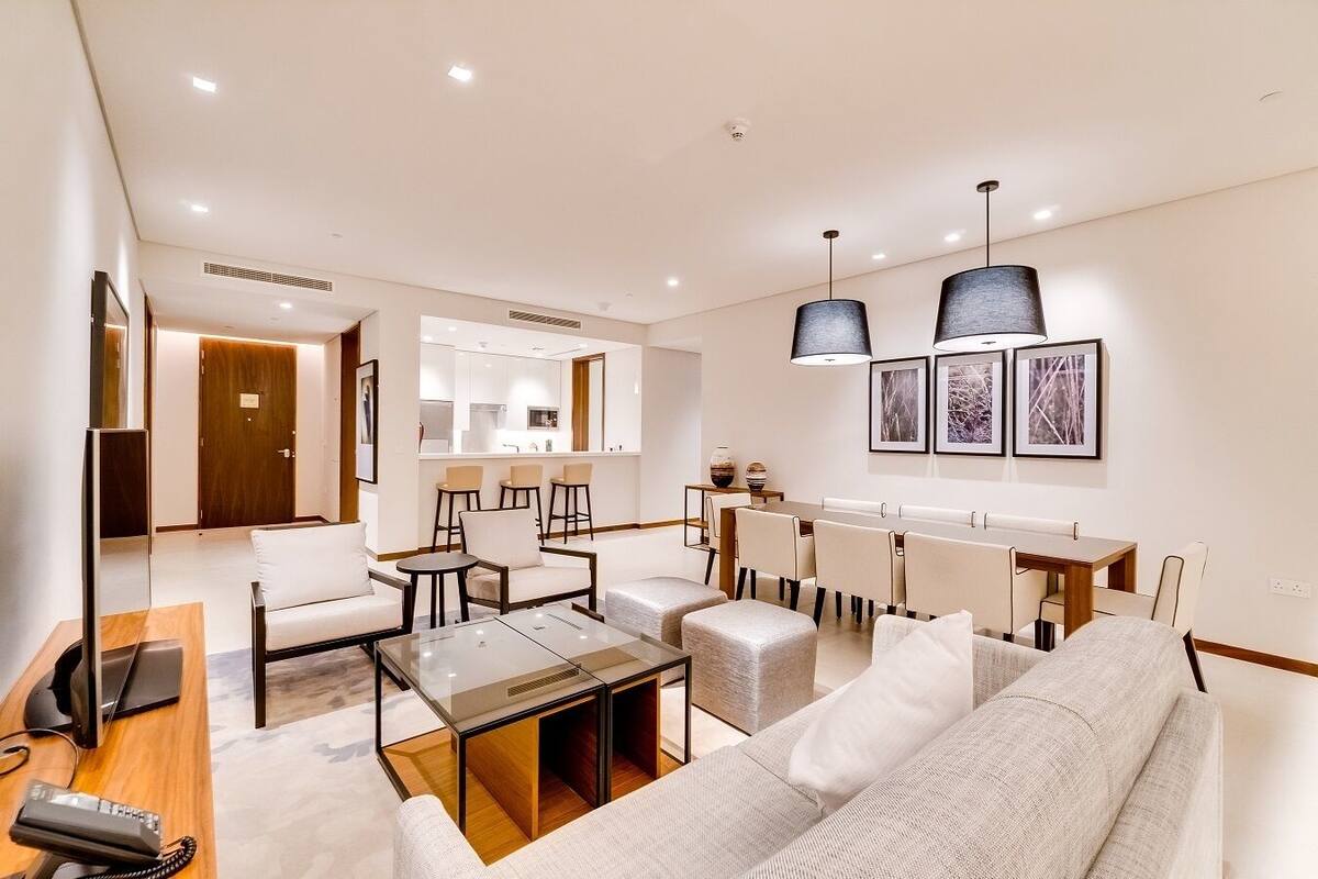 A modern living room with a sofa, coffee table, and dining area.