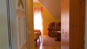 Ein Flur mit einem Bett, einem Sessel und einem Kleiderschrank.
