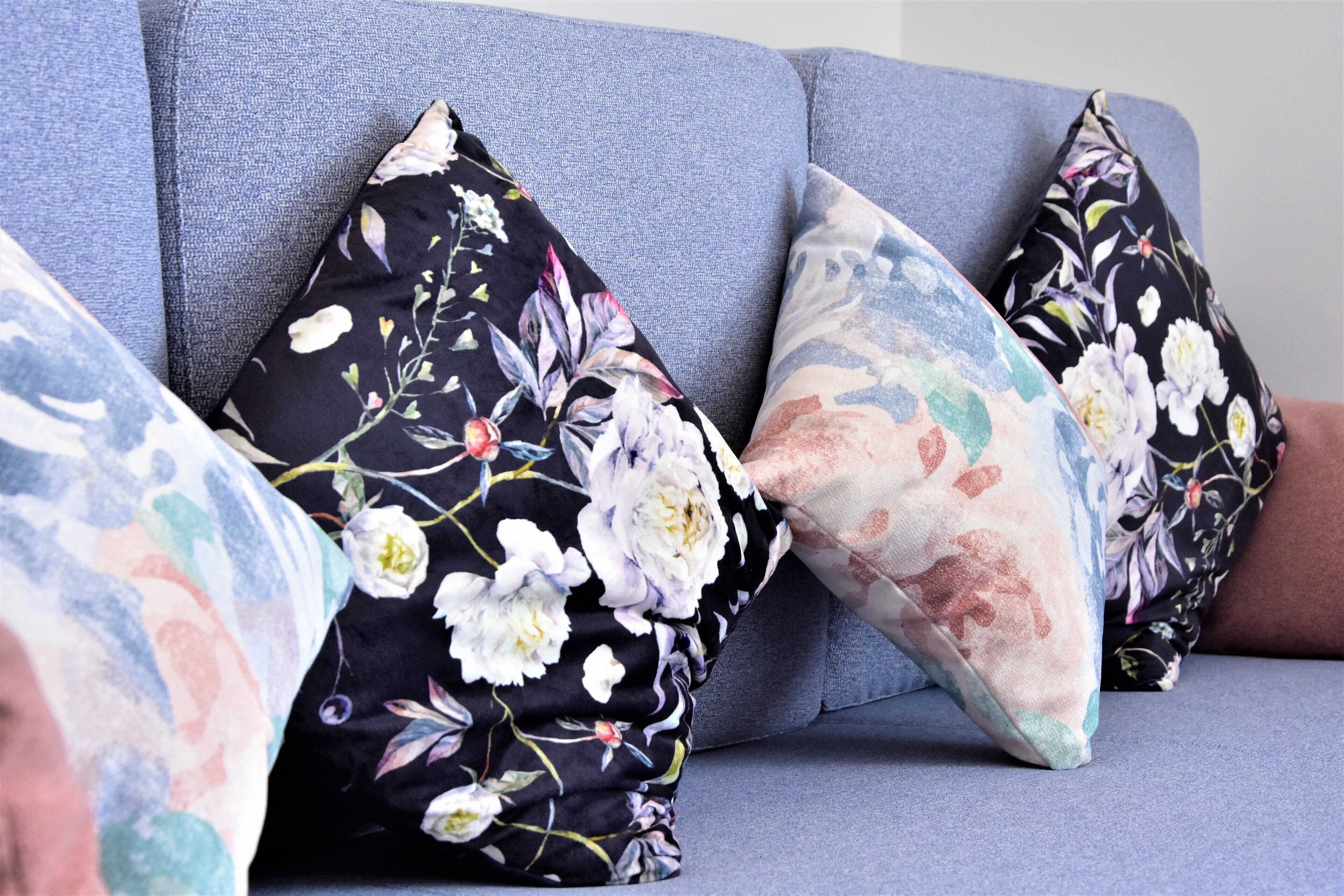 A sofa with floral-patterned cushions.