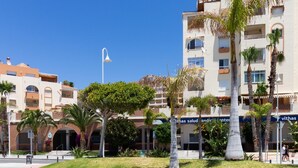 A building with a medical center sign, surrounded by palm trees and a clear blue sky.