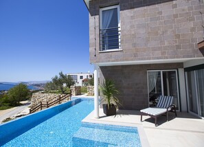 A modern house with a swimming pool, stone walls, and a view of the sea. - Royal Villa (Podstrana)