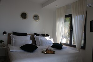 A neatly made bed with white and black pillows, a tray with tea sets, and two wall-mounted mirrors. - Royal Villa (Podstrana)