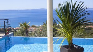 A pool with a clear view of the sea and distant land.