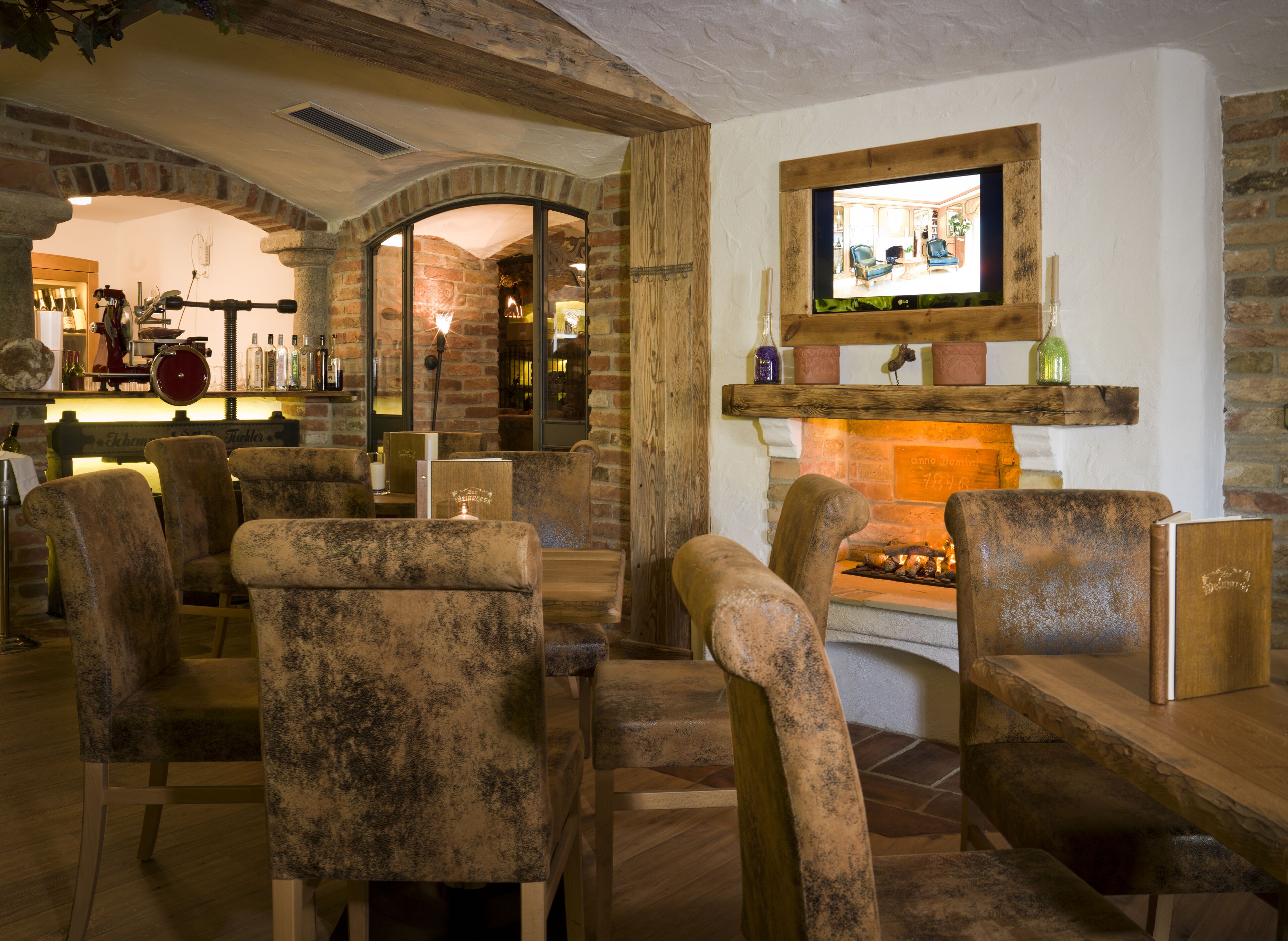 Un interior acogedor con paredes de piedra rústica, chimenea y muebles de madera.
