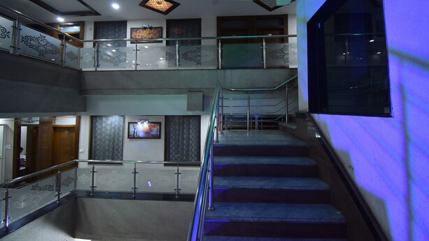 A multi-level interior with a staircase, glass railings, and a ceiling fan.