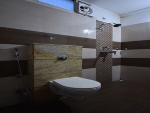 Un baño con inodoro, ducha y aire acondicionado de pared.