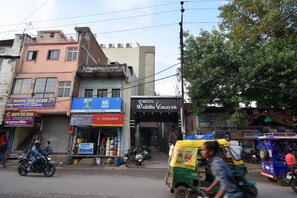 Vista de la calle con un hotel llamado 'Hotel Siddhi Vinayak' y varias tiendas.
