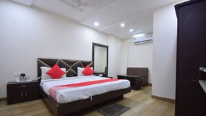 A neatly arranged hotel room with a large bed, bedside tables, a chair, and a wardrobe.