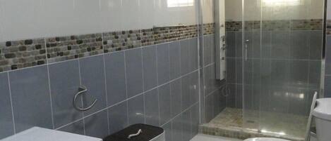 Un baño con ducha, inodoro y lavamanos.