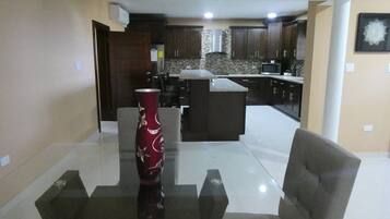Una cocina moderna con armarios de madera oscura, una isla central y un microondas.