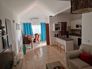 A modern apartment with a dining area, kitchen, and living space.