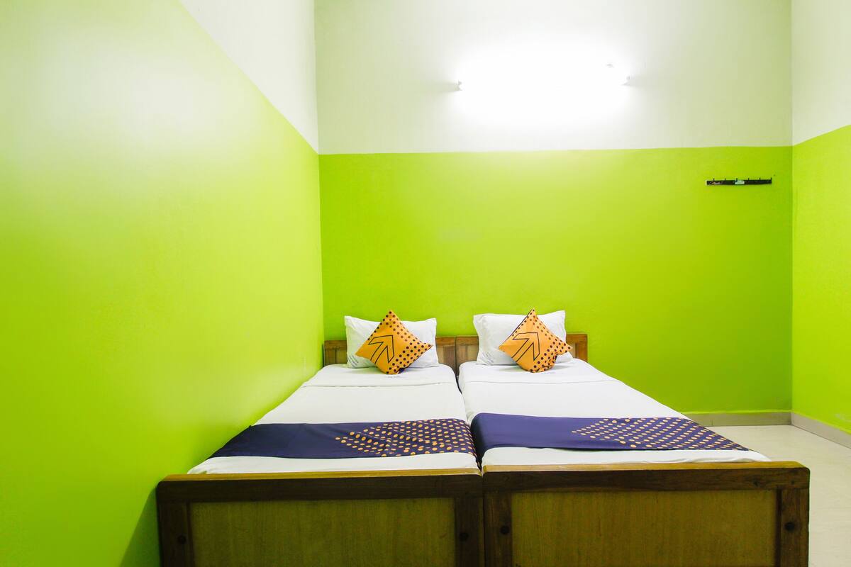 Een kamer met twee bedden, elk voorzien van een kussen en een deken.