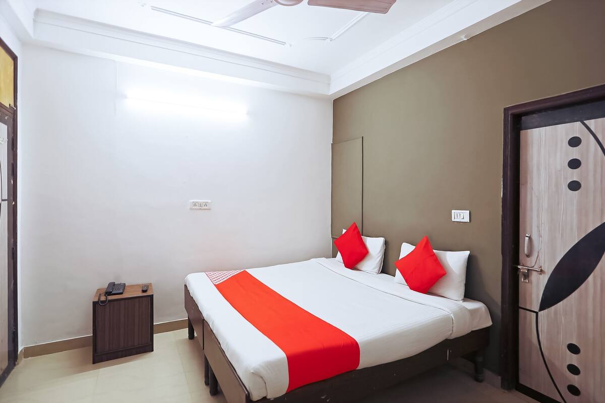 Une chambre d’hôtel avec un lit, une table de chevet avec un téléphone et une armoire.