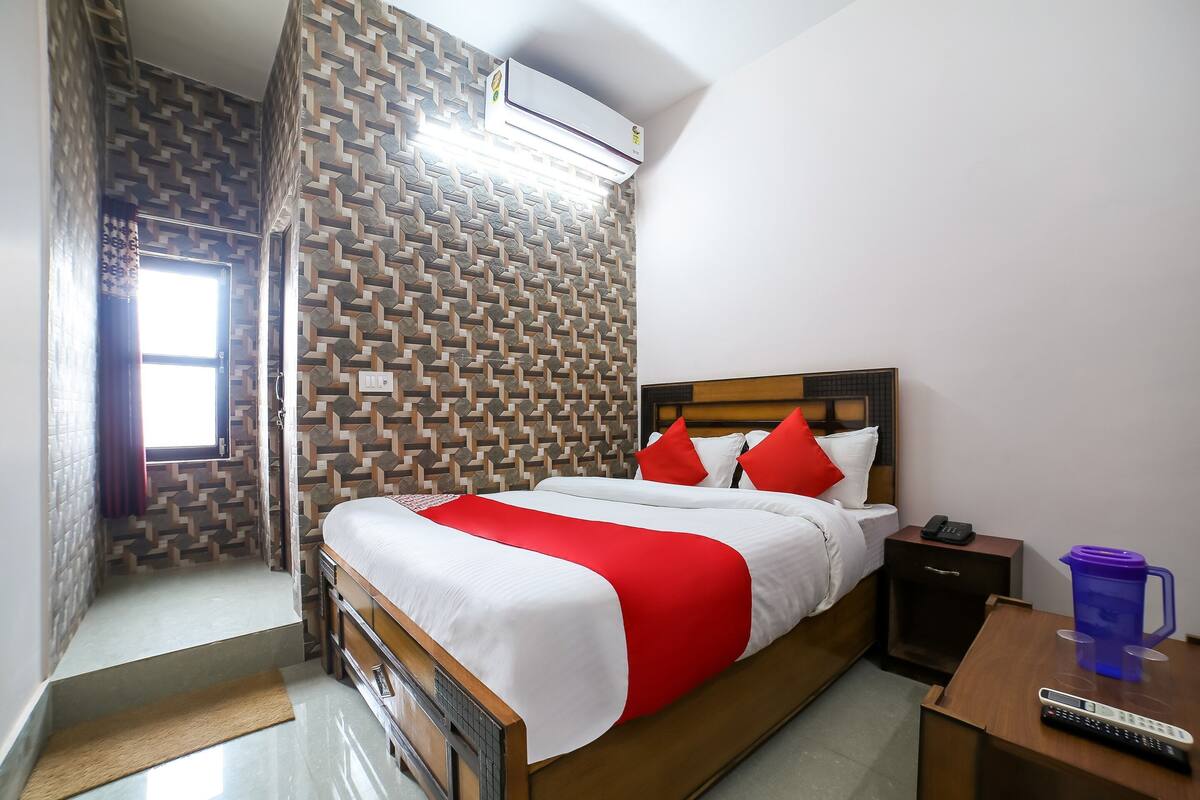 Ein Hotelzimmer mit Bett, Nachttisch und Fenster.