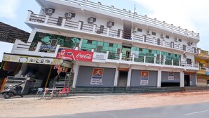 A multi-story building with a Coca-Cola sign, a restaurant named Kalindi Hotel & Restaurant, and several closed shutters with Bangur signage.