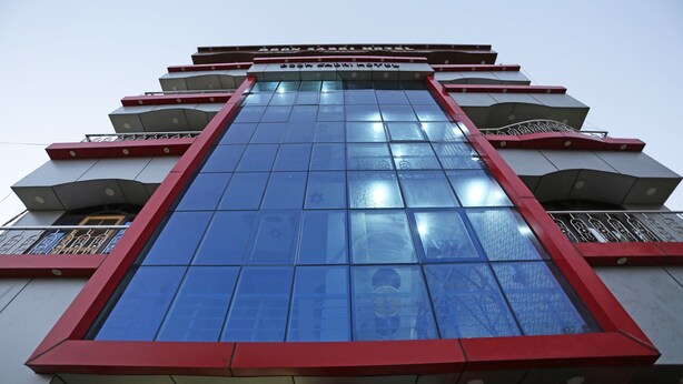 A building with a prominent glass facade and red accents.