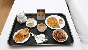A tray with a teapot, cup, two plates of food, a bowl of soup, and a bowl of nuts. - Capital O 62363 N R Residency (Bengaluru)