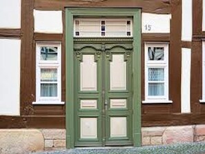 A traditional building with a green door and white-framed windows. - SPOT ON 41656 Hotel Maruti (Tinsukia)
