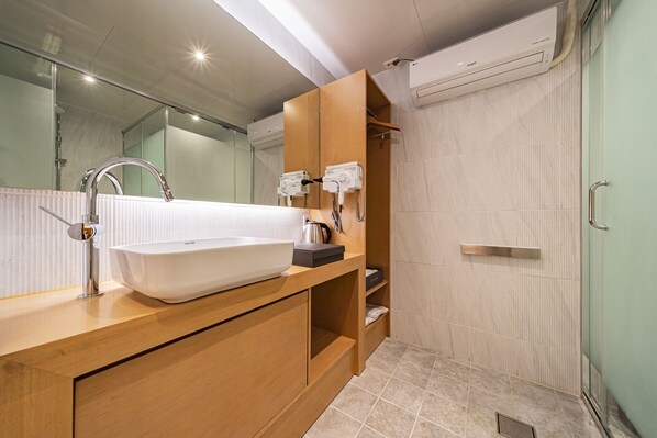 A modern bathroom with a large white sink, a glass shower enclosure, and a wooden vanity. - Hotel Jara (Gapyeong)
