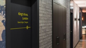 A hallway with a sign reading "King's Cross, London" and a dotted line with a circle. - Metro Hostel (Kyiv)